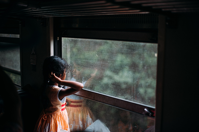 little girl looking out train window